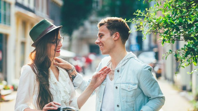 Young couple with bicycle through the city streets