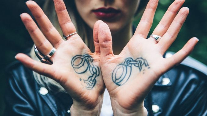 a5fdf750-8c6b-43e4-ac4d-b3ba3b1aa15e-womans-palms-with-handcuff-tattoos